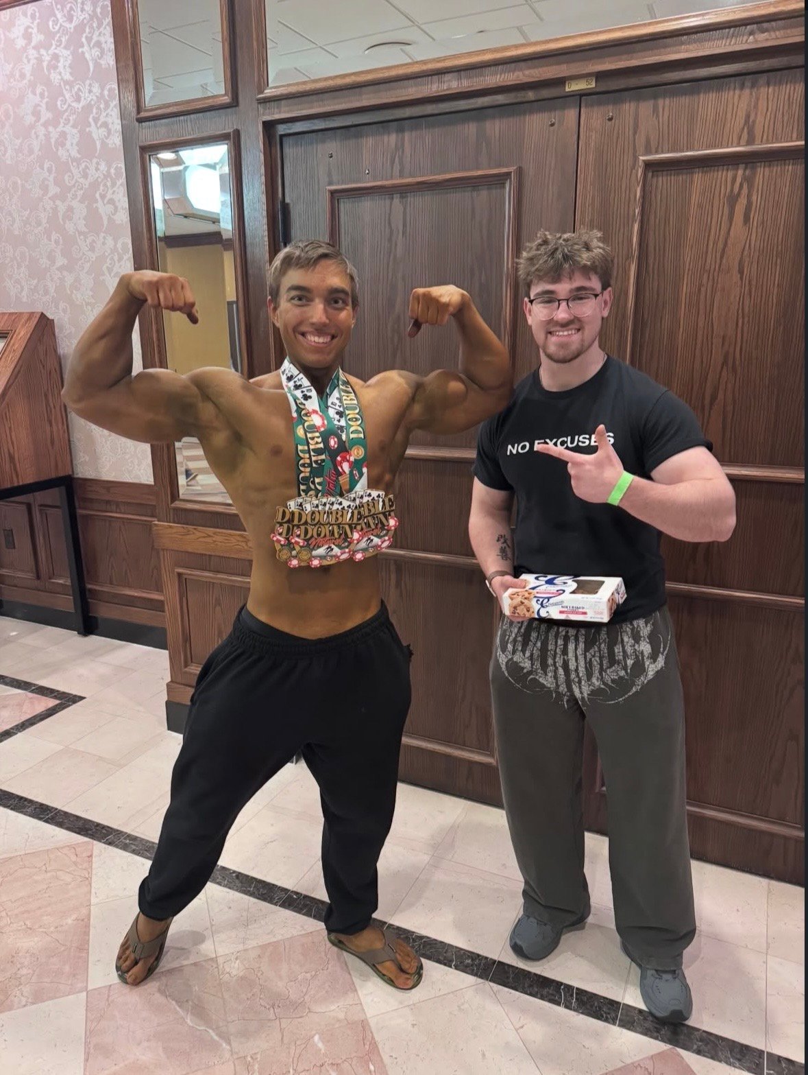 Lance with his bodybuilding client Nick at a show, Nick flexing in a Double Down medal pose